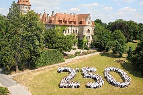Ausblick aufs Firmenjubiläum im nächsten Jahr: Am Mittwoch formierten sich rund 500 Mitarbeiter im romantischen Steiner Schlossgarten zur Jubel-Zahl.