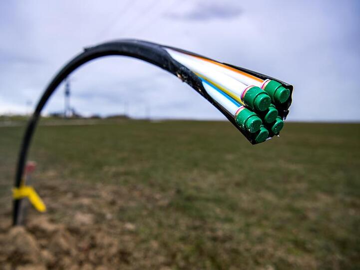 Ein Leerrohr für Glasfaser wurde auf einem Acker verlegt, aus dem es noch herausragt. Foto: Sina Schuldt/dpa/Archivbild