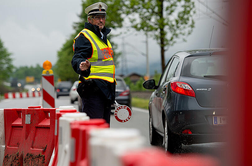 Ein Polizist kontrolliert am 26.05.2015 am Grenzübergang in Mittenwald die von Österreich nach Deutschland einreisenden Autos.