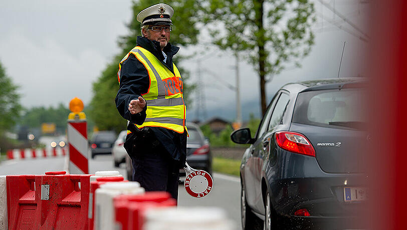 Ein Polizist kontrolliert am 26.05.2015 am Grenzübergang in Mittenwald die von Österreich nach Deutschland einreisenden Autos. Ein Polizist kontrolliert am 26.05.2015 am Grenzübergang in Mittenwald die von Österreich nach Deutschland einreisenden Autos.