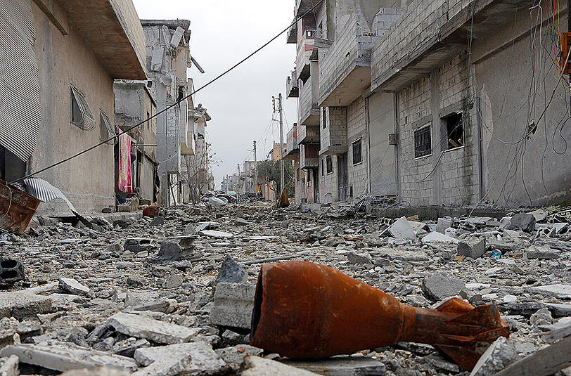 Eine Mörsergranate liegt in einer völlig zerstörten Straße im syrischen
Kobane: In den Krisenregionen eskaliert die Lage zunehmend.