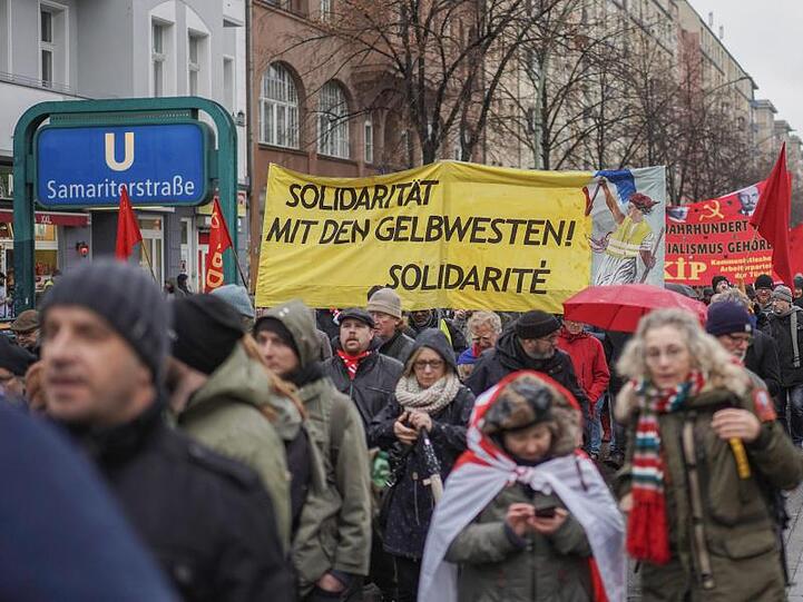 Teilnehmer des Demonstrationszugs tragen ein Transparent mit der Aufschrift "Solidarität mit den Gelbwesten!".
