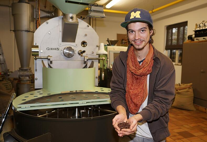 Juniorchef Benjamin Schneider präsentiert Bohnen &ndash; im Familienbetrieb wird der Kaffee im Langzeitröstverfahren produziert.