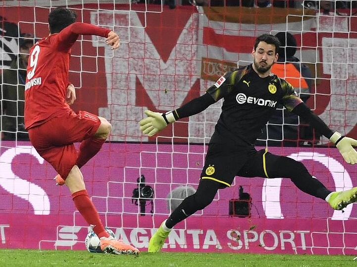 Münchens Robert Lewandowski (l.) erzielt das Tor zum 3:0 gegen Roman Bürki. Foto: Sven Hoppe/dpa