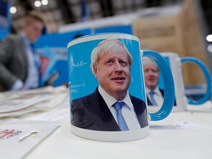 Tassen mit dem Gesicht von Premierminister Boris Johnson auf dem Parteitag.