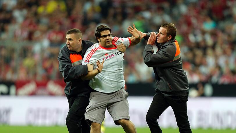 Er rennt in der 55. Minute auf den Platz und sorgt kurz für Aufsehen: Der Bayern-Fan und Flitzer wird von den Sicherheitskräften aber schnell gestellt. Er rennt in der 55. Minute auf den Platz und sorgt kurz für Aufsehen: Der Bayern-Fan und Flitzer wird von den Sicherheitskräften aber schnell gestellt.