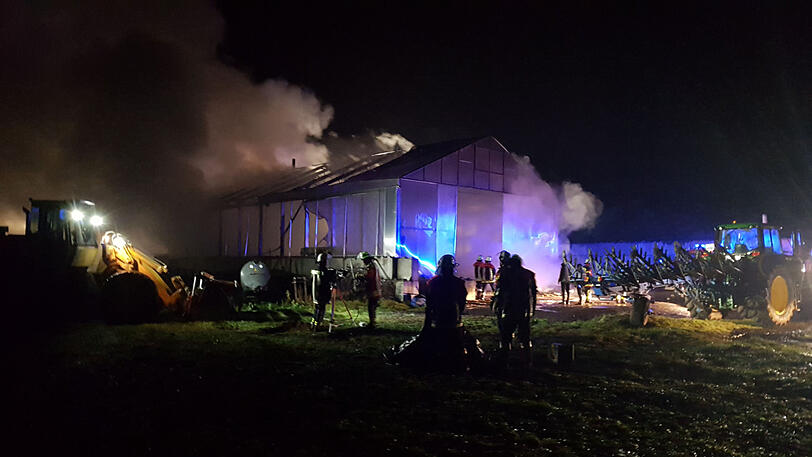 Einsatzkräfte der Feuerwehr löschen den brennenden Stall.