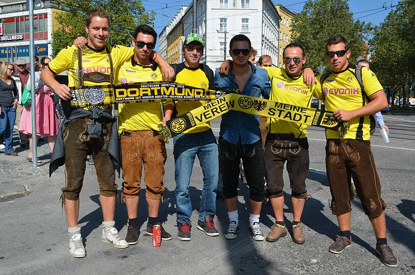BVB-Fans aus Lindau, gehen erst auf die Wiesn und dann direkt weiter zum Spiel. BVB-Trikot und Lederhos'n, ob das passt? Ein Bayern-Fan (schwarzes shirt) durfte auch mit, aber nur ohne Trikot. Heute is er auch für den BVB Manu, 3. v.l.: Wir sind uns einig, dass wir die Löwen weghauen. Ich tippe 5:1!"