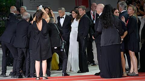 Brad Pitt und Ines de Ramon (in Weiß) zeigten sich am 1. September bei der Premiere von "Wolfs" in Venedig auf dem roten Teppich.