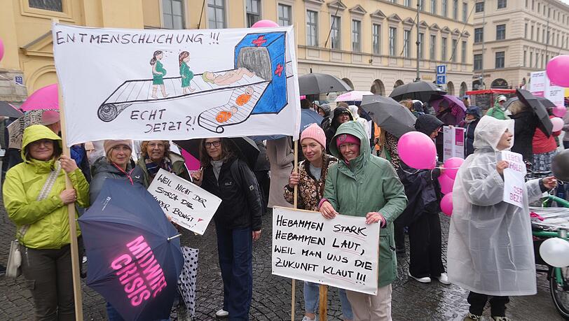 Viele Hebammen haben sich am Montag auf dem Odeonsplatz versammelt, um gegen den neuen Hebammenhilfevertrag zu demonstrieren. Sie fürchten, dadurch weniger Geld für gleichbleibende Arbeit und Verantwortung zu bekommen.