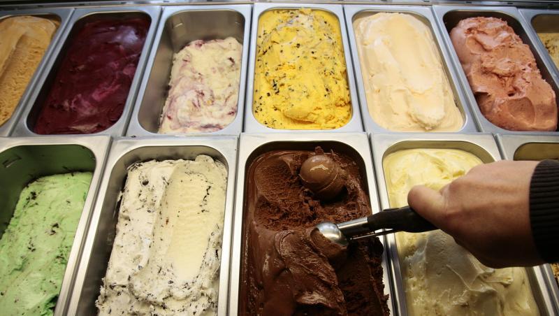 Ein Eisverkäufer formt eine Kugel Eis.