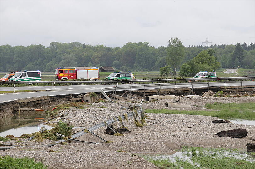... direkt neben der Fahrbahn steht das Wasser. In der zerstörten Leitplanke hängen Fetzen von Treibgut.