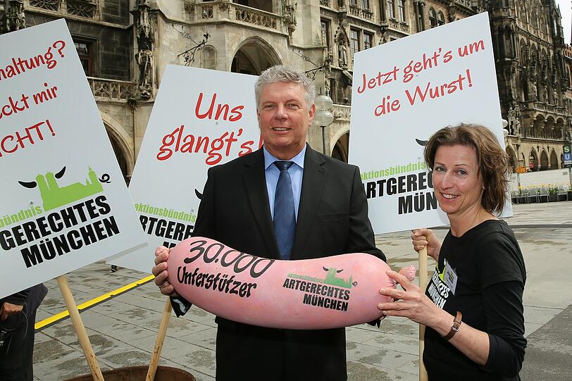 Oberbürgermeister Dieter Reiter (SPD) mit Stephanie Weigel vom Aktionsbündnis und der stimmgewaltigen Wurst.