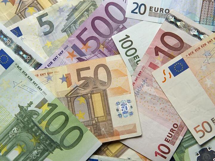 Zahlreiche Euro-Banknoten liegen übereinander. Foto: Daniel Reinhardt/Archivbild