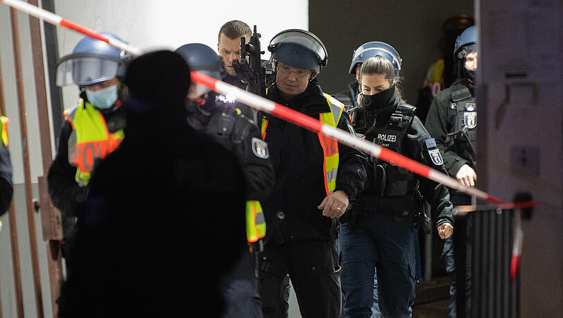 Mit Maschinenpistolen bewaffnete Polizeibeamte verlassen ein Grundstück an der Stresemannstraße in Kreuzberg.