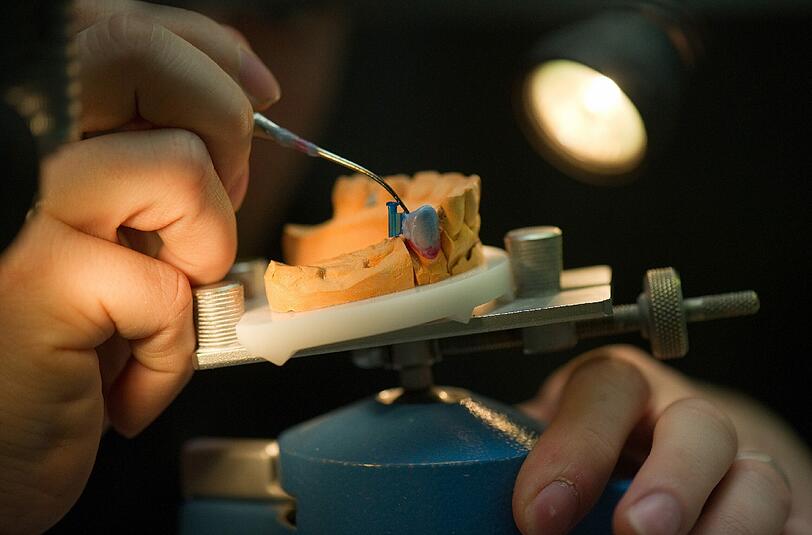 Ein Zahntechniker bei der Arbeit. Foto: Arno Burgi/Illustration