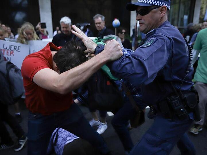 In Sydney kommt es zu einer Rangelei zwischen einem Demonstranten und einem Polizisten.