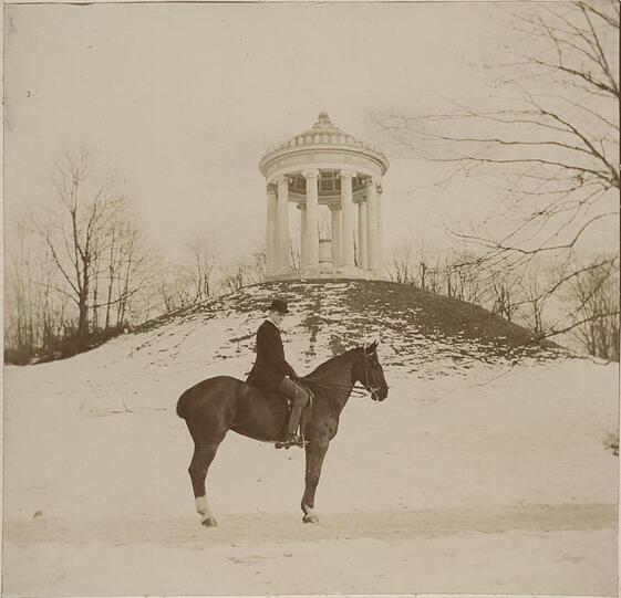 1910: Im Englischen Garten am Monopteros hat sich so gut wie nichts verändert. Reitsportler gibt es immer noch, bloß haben die jetzt eigene Reitwege. Und Schlittenfahren war damals offensichtlich noch nicht so in Mode.