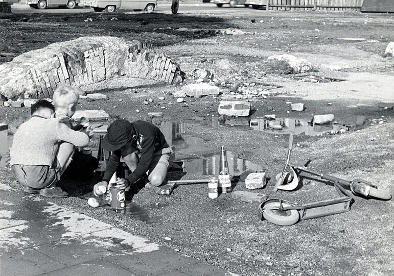 Kinder spielen am Rande von Kriegsruinen.