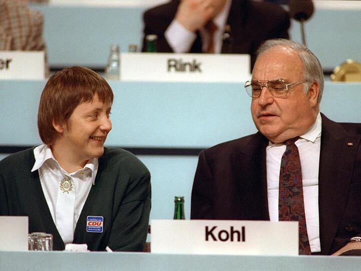 Der damalige Bundeskanzler Helmut Kohl (CDU) und Angela Merkel (CDU), ihrerzeit Frauenministerin, sprechen während des Parteitags der CDU im Kulturpalast 1991.