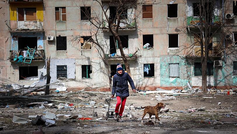 Ein Mann und sein Hund inmitten der Zerstörung am Stadtrand von Mariupol. Ein Mann und sein Hund inmitten der Zerstörung am Stadtrand von Mariupol.