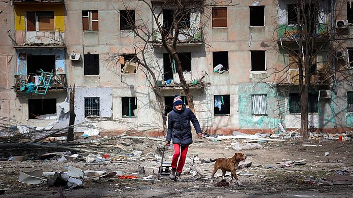 Ein Mann und sein Hund inmitten der Zerstörung am Stadtrand von Mariupol.