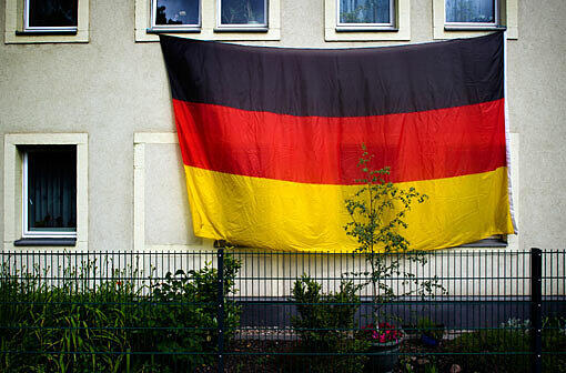Darf ich Fahnen raushängen? - Kleine Fahnen aus dem Fenster einer Mietwohnung zu hängen, ist okay. Müssen sie eigens an der Fassade befestigt werden, erst den Vermieter fragen!