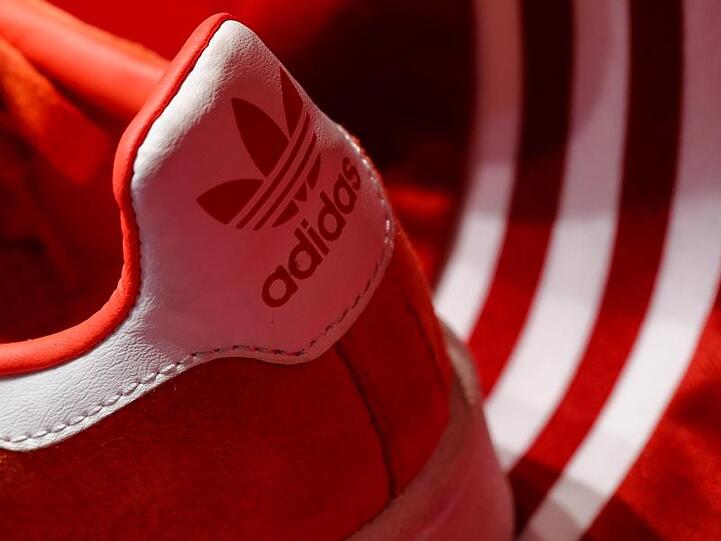 Ein Schuh des Sportartikelherstellers adidas wird am Rande der Hauptversammlung ausgestellt. Foto: Daniel Karmann/dpa/Archivbild