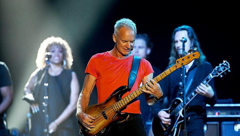 Das einfache, aber effektive Farbkonzept: Die ganze Band trägt Schwarz, nur Stings T-Shirt leuchtet in Orange.