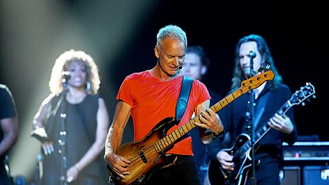 Das einfache, aber effektive Farbkonzept: Die ganze Band trägt Schwarz, nur Stings T-Shirt leuchtet in Orange.