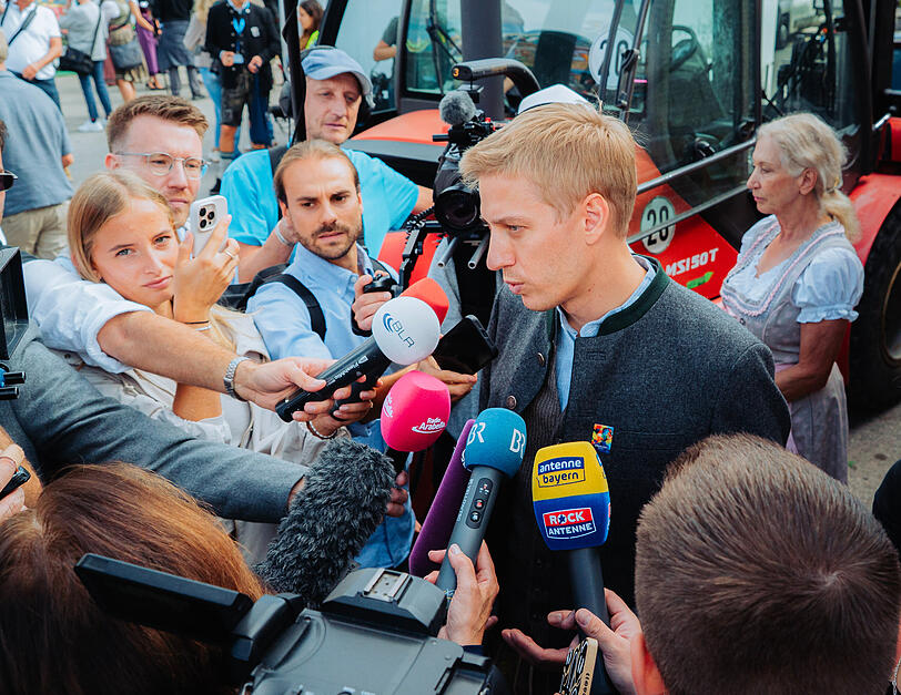 Oberb&uuml;rgermeister Dominik Krause (Gr&uuml;ne) ist beim offiziellen Presserundgang &uuml;ber die Wiesn umzingelt von Reportern. Das Interesse ist enorm.