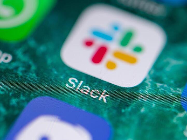 Der Bildschirm eines iPhones zeigt die Messenger-App Slack.
