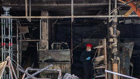 Ein Brandermittler in der Ruine eines attackierten türkischen Geschäftes in Waldkraiburg. Foto: Lino Mirgeler/dpa/Archivbild