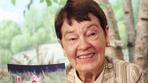 Loki Schmidt präsentiert die Bach-Nelkenwurz (Geum rivale) als Blume des Jahres 2007.