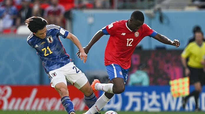 Ayase Ueda (l)aus Japan und Joel Campbell aus Costa Rica kämpfen um den Ball.