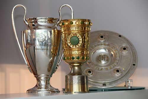 Um diese Trophäen geht es: Pokale der Champions-League und des DFB-Cups sowie die Meisterschale