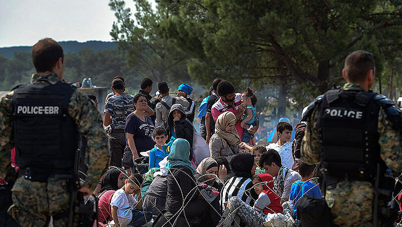 Polizisten in Schutzausrüstung bewachen in Gevgelije die mazedonisch-griechische Grenze. Polizisten in Schutzausrüstung bewachen in Gevgelije die mazedonisch-griechische Grenze.
