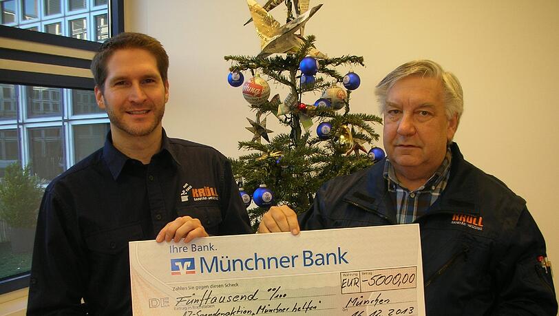Bescherung vor dem Weihnachtsbaum: Florian (links) und Eduard Kröll mit einem Scheck über 5000 Euro. Bescherung vor dem Weihnachtsbaum: Florian (links) und Eduard Kröll mit einem Scheck über 5000 Euro.