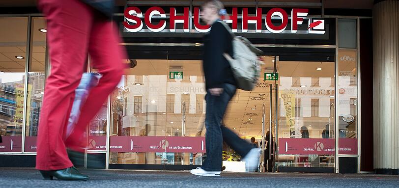 Passanten gehen in Berlin an einer Filiale des Schuhhandelunternehmens Schuhhof entlang (Foto vom 30.03.12).