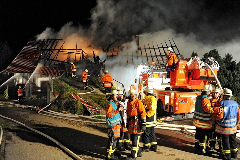Hier ereignete sich die Tragödie: Feuerwehrleute stehen in der Nacht zum Samstag in Ratzenried vor dem brennenden Hof. Die Bilder von den Löscharbeiten