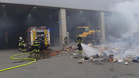 Die Feuerwehr löscht die rauchende Ladung des Müllfahrzeugs.