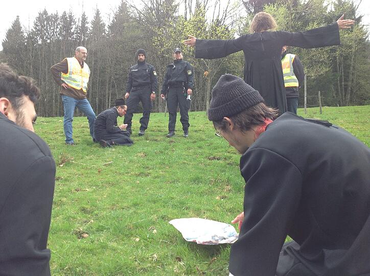Als die Polizei sie auffordert, das Privatgrundstück zu verlassen, wirft sich einer der Schauspieler auf den Boden und imitiert eine Katze.