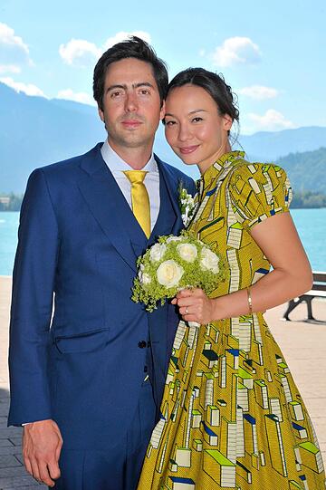 Das Brautpaar David Dietl und Lydie Leschak vor dem Tegernsee mit den Alpen im Hintergrund.