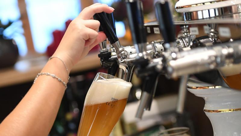 Eine Bedienung zapft Bier in einem Wirtshaus.