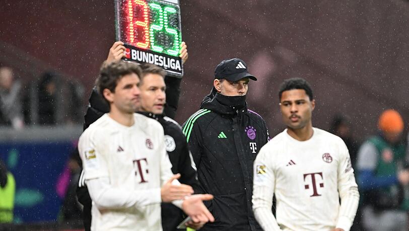 Münchens Trainer Thomas Tuchel steht zwischen Thomas Müller (l) und Serge Gnabry während des Spiels.