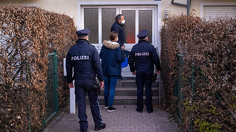 Polizeibeamte stehen in den frühen Morgenstunden, während einer bayernweiten Polizeiaktion gegen Beleidigungen von Politikern, vor dem Haus einer verdächtigen Person.