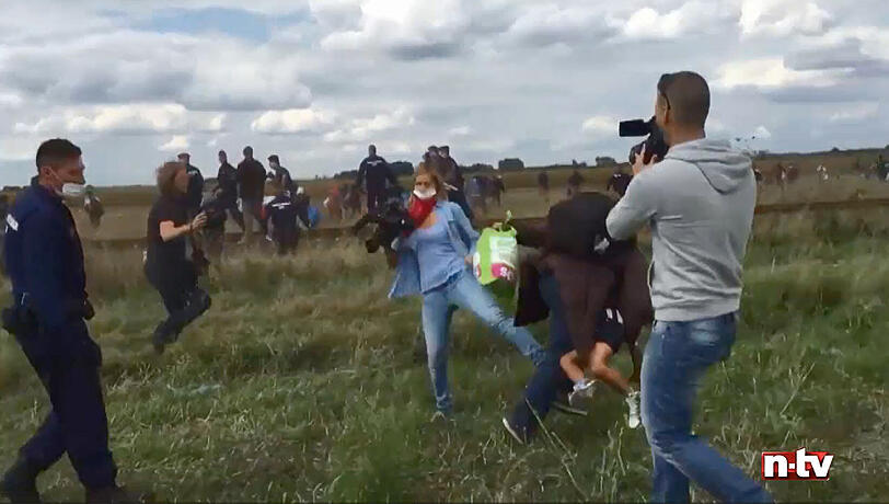 Mit gezielten Fußtritten versucht die ungarische Journalistin Petra Laszlo Flüchtlinge zu Fall zu bringen.