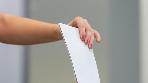 Eine Wählerin wirft bei der Stimmabgabe ihren Wahlzettel in eine Wahlurne.
