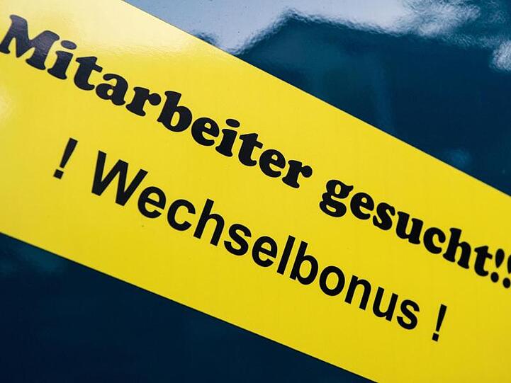 "Mitarbeiter gesucht!!! Wechselbonus!" steht auf einem Schild. Foto: Arno Burgi/Archiv