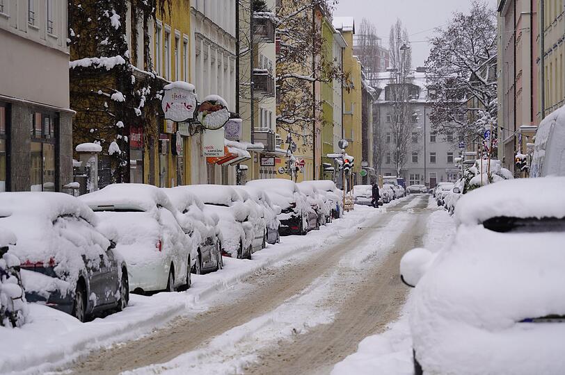 Die geparkten Autos in der Innenstadt sind eingeschneit.